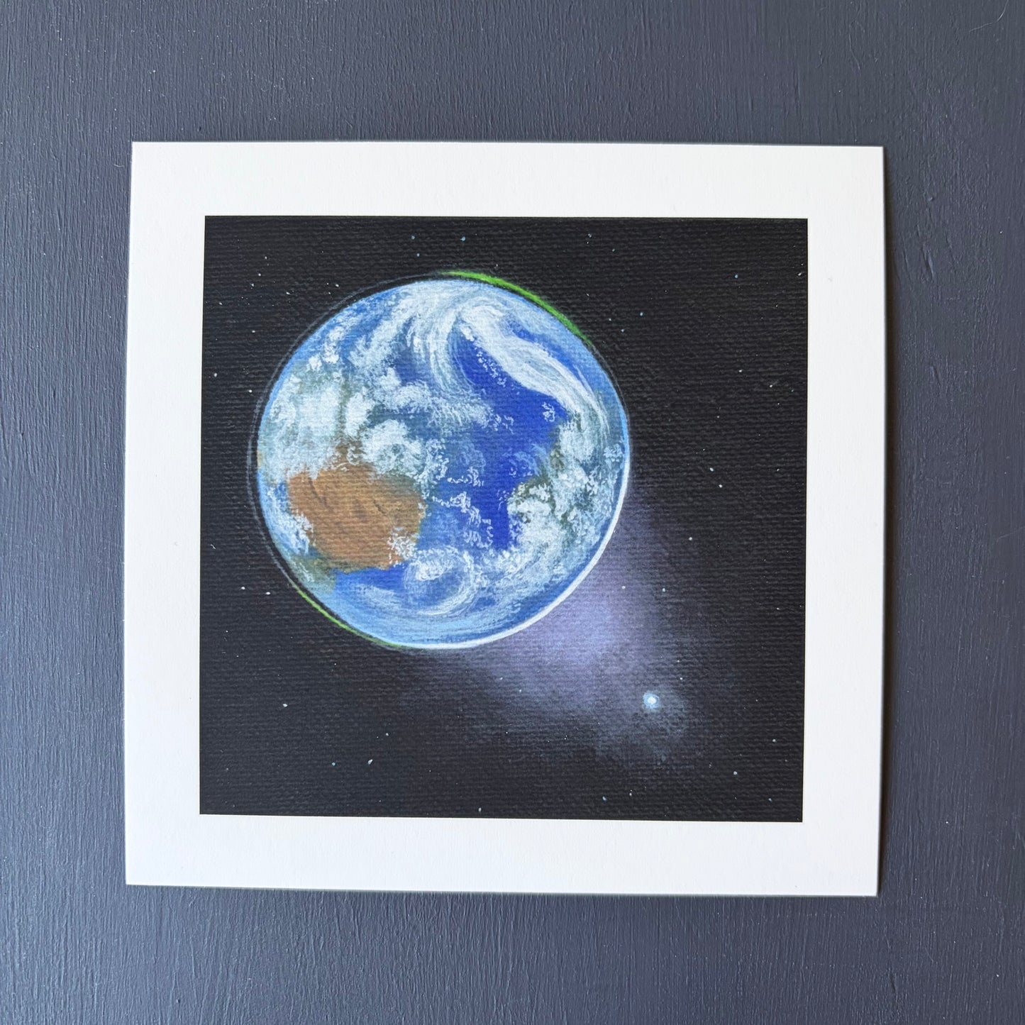 mini print of Earth from space, Venus in the bottom right, and a black background with a few stars.