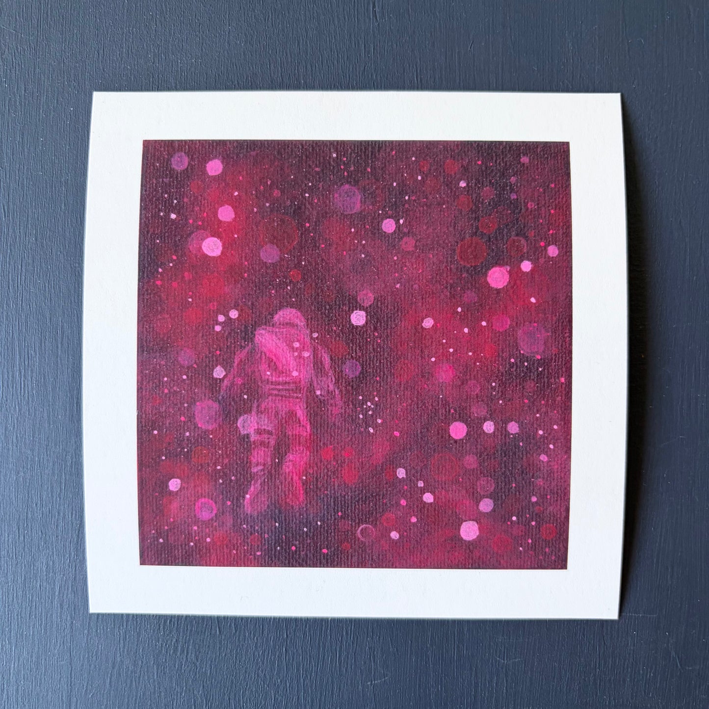 Mini print of astronaut floating surrounded by red and pink bokeh