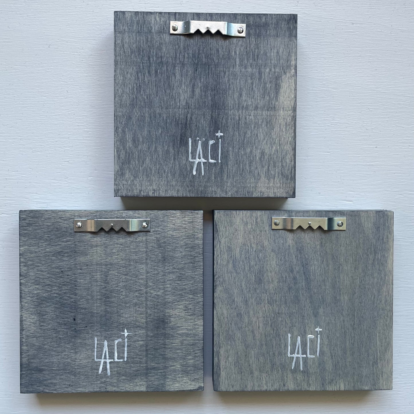 Back of three shadowbox frames each with sawtooth hanger at the top and my signature at the bottom