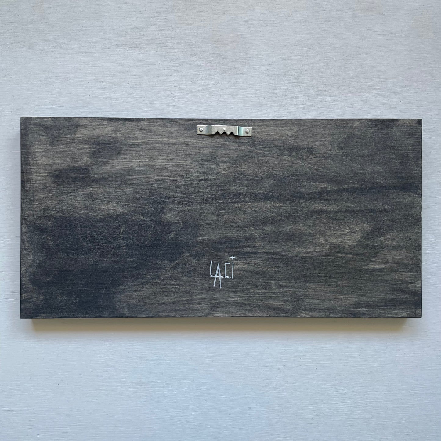 Back of the frame with a sawtooth hanger at the top and my signature at the bottom
