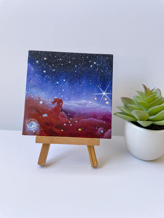 Mini Horsehead Nebula painting on small wooden easel next to fake plant