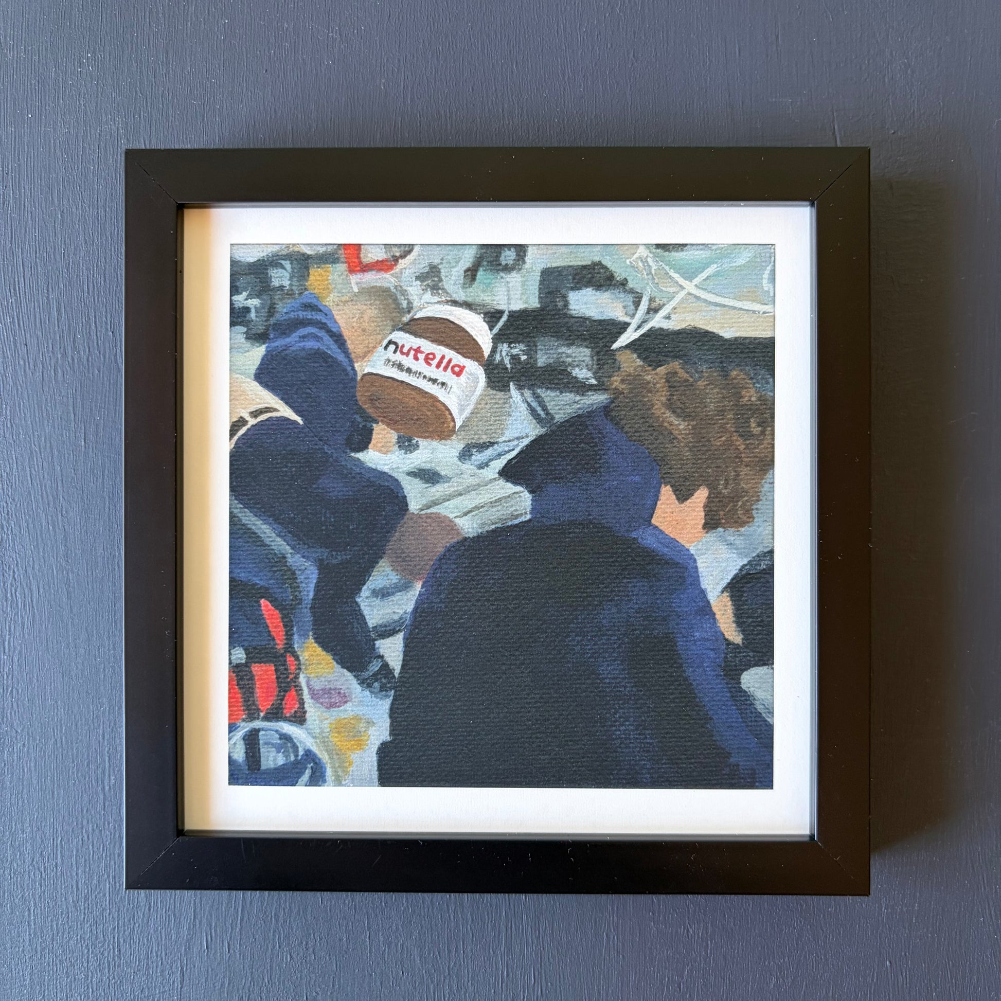 mini print in black frame of Nutella jar in foreground and Artemis astronauts in the background