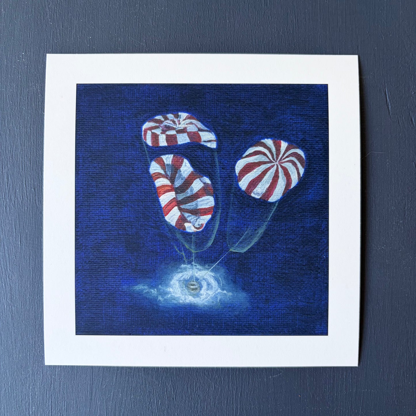 mini print of 3 red and white striped parachutes deploying on Orion capsule landing in ocean