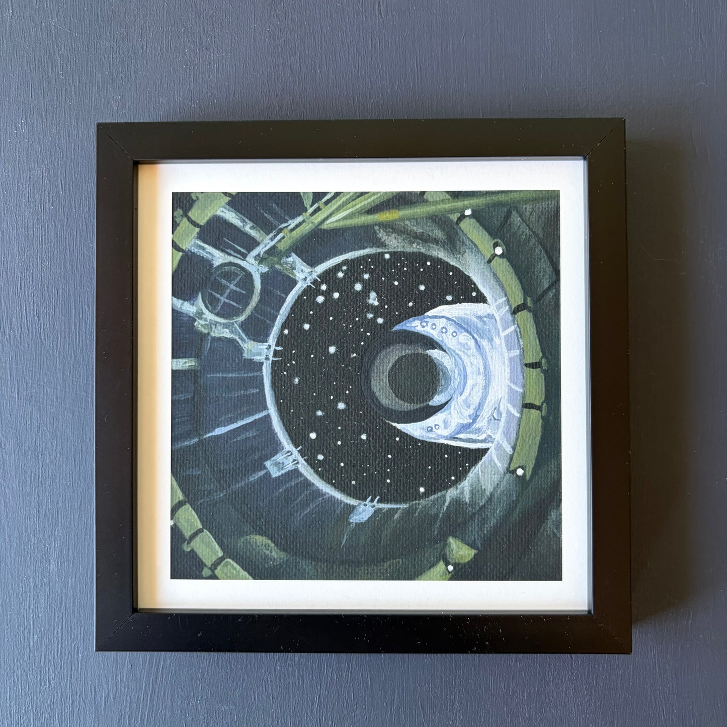 mini print in black frame of spacecraft separation shown from the inside