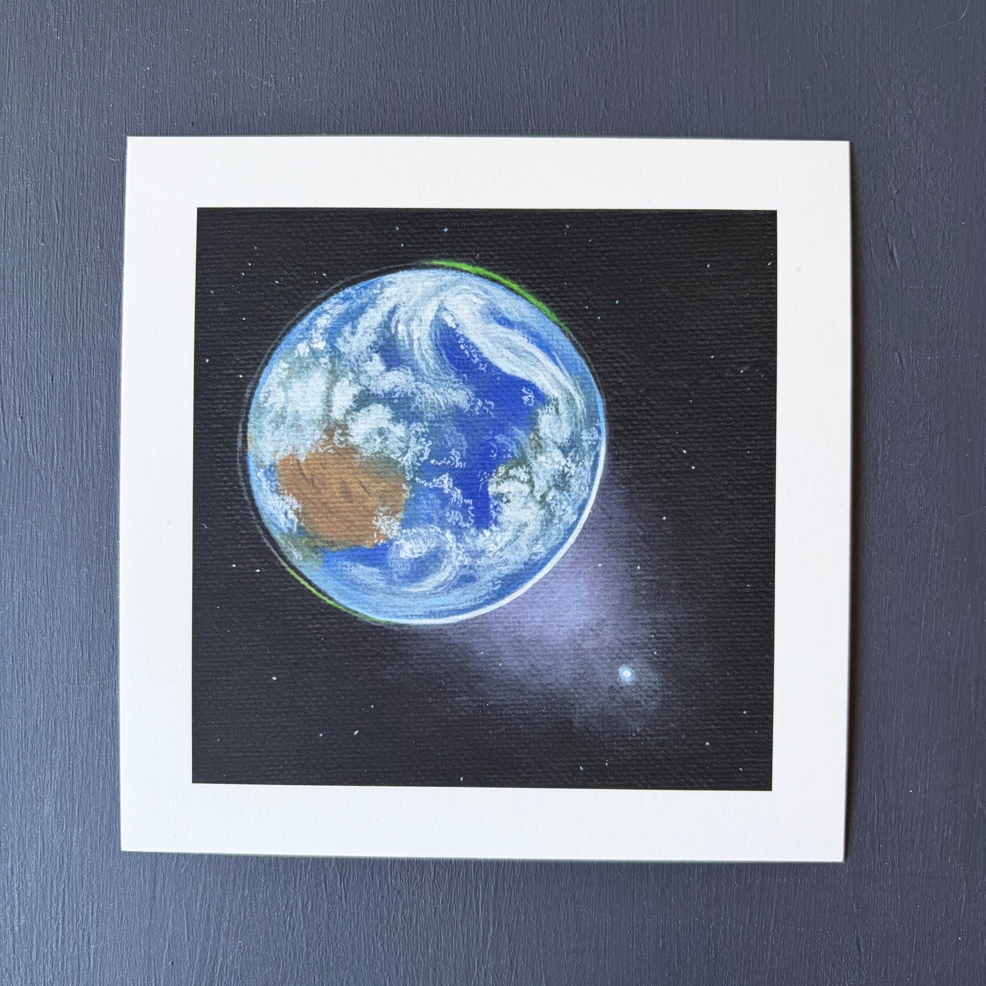 mini print of Earth from space, Venus in the bottom right, and a black background with a few stars.