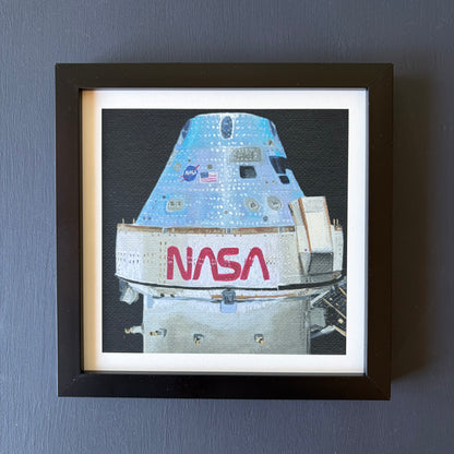 mini print in black frame of Orion capsule  on a black background