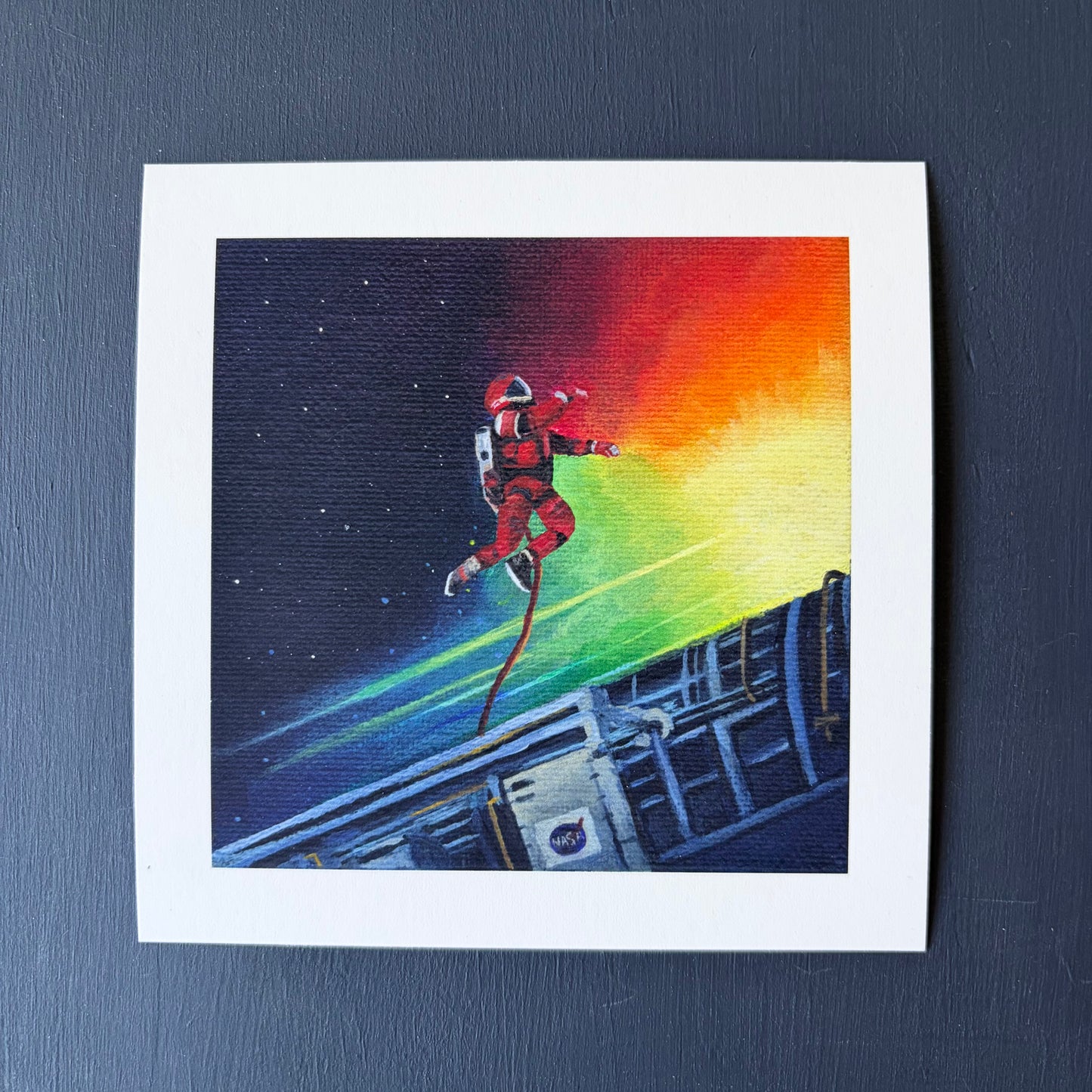 Mini print of an astronaut tethered to a spaceship with a colorful background