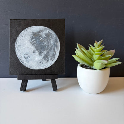 mini painting on easel of the Moon's surface on a black background