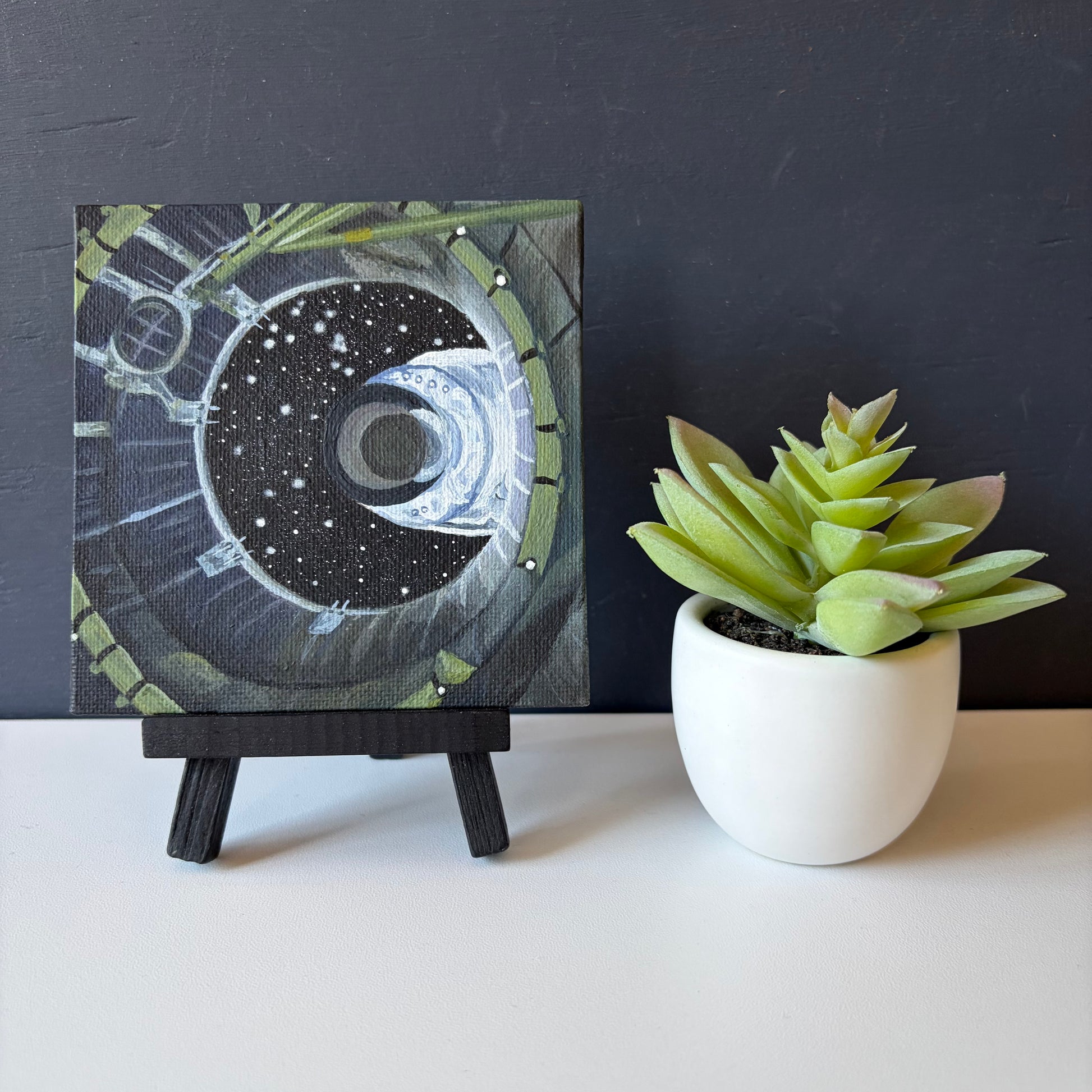 mini painting on easel of spacecraft separation shown from the inside