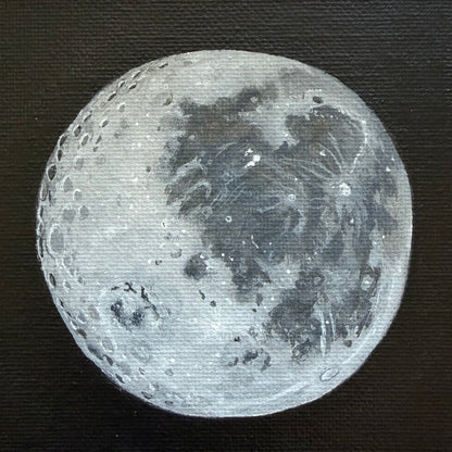 Close up of mini painting of the Moon's surface on a black background