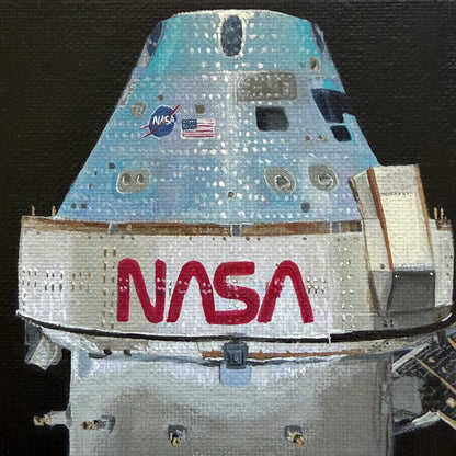 Close up of mini painting of Orion capsule  on a black background