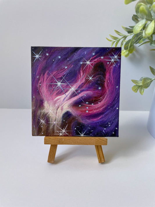 Mini pink and purple nebula painting on a small wooden easel