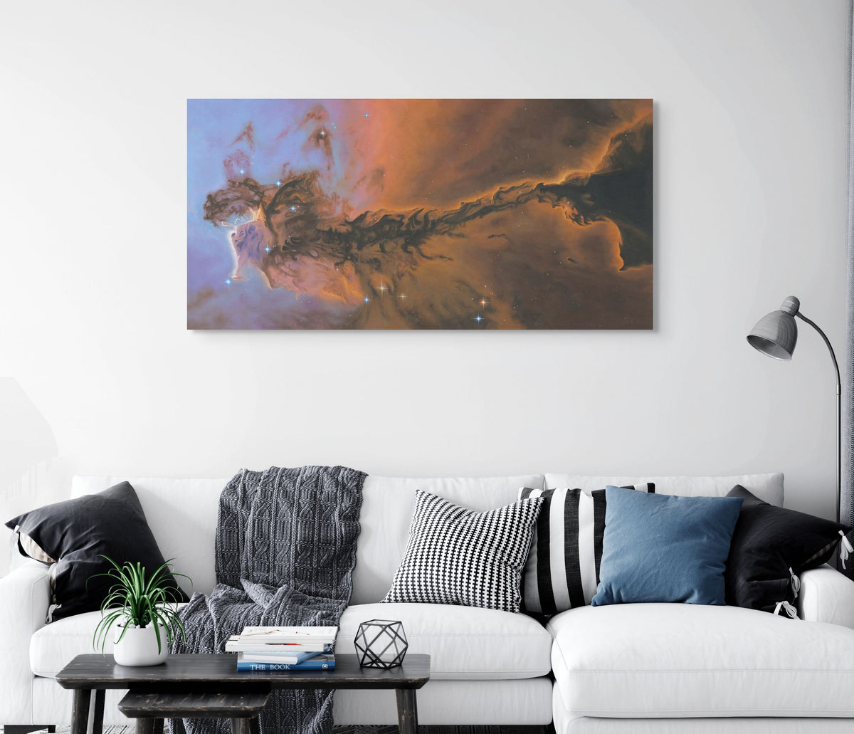 Living room with a white sofa, decorative pillows, and a large nebula painting on the wall.