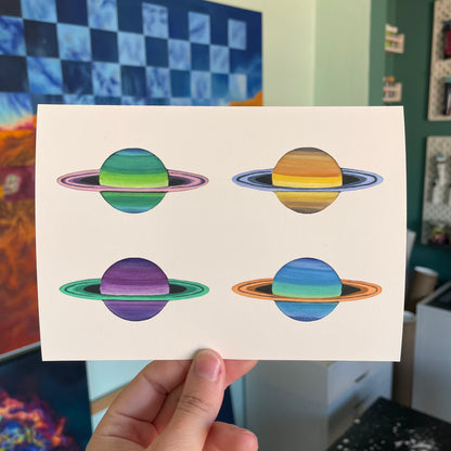 5x7 inch print of four mini colorful Saturns in my left hand