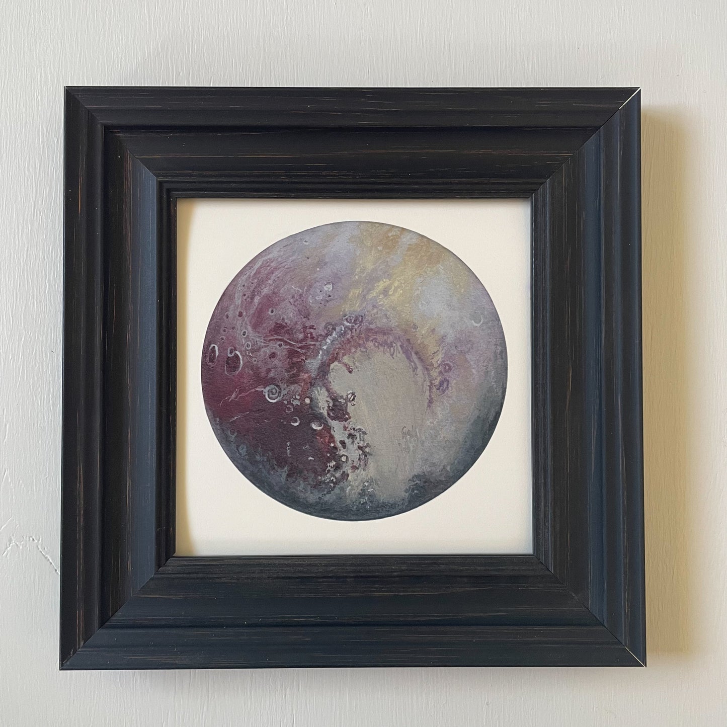 Print of Pluto in black frame with white background