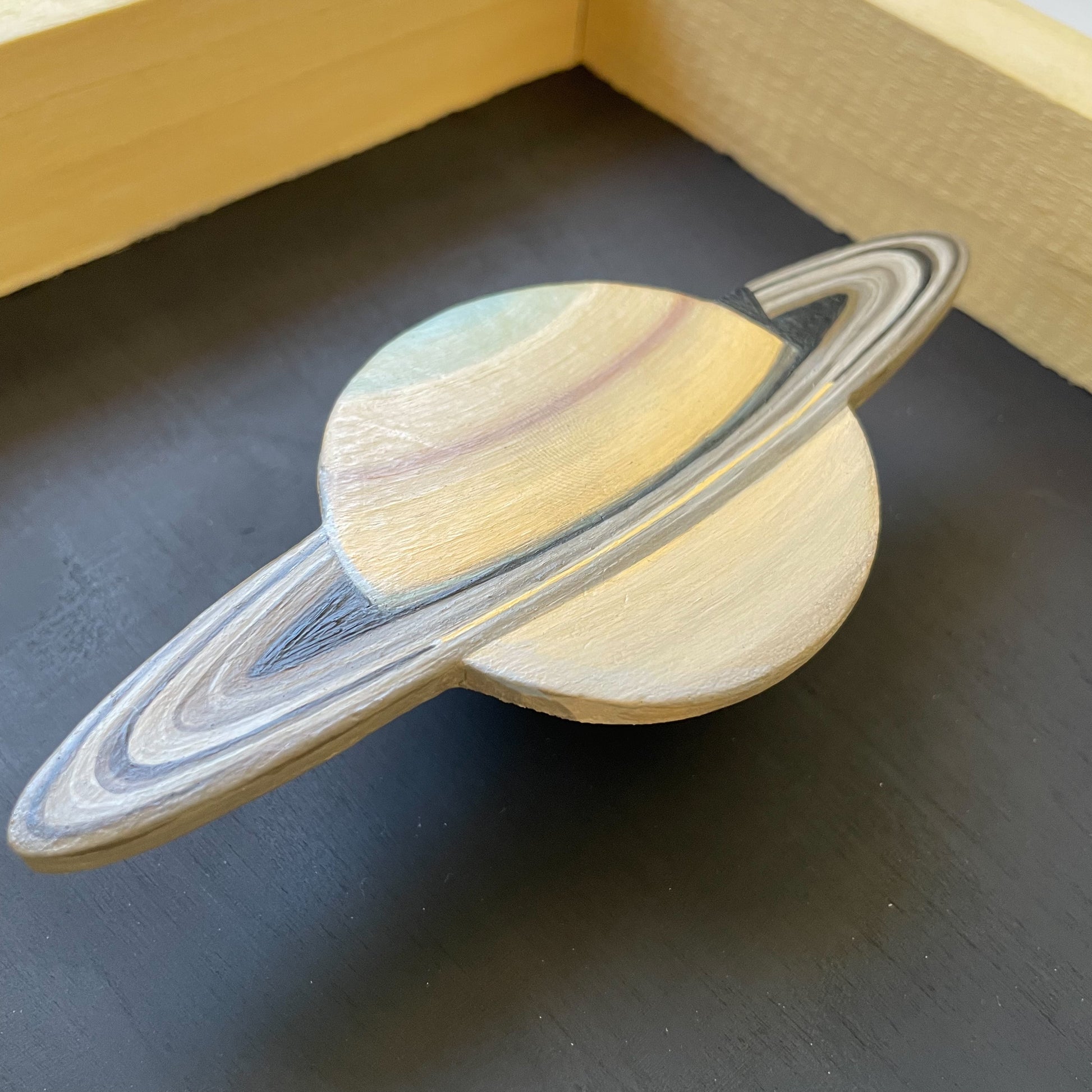 Close up of clay Saturn floating in frame