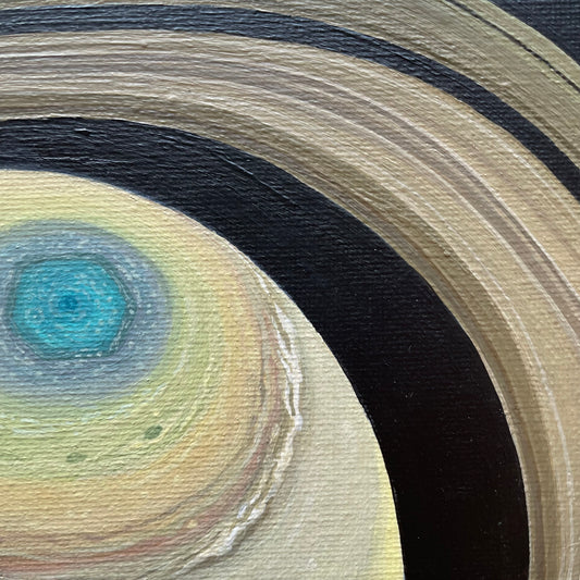 Close up of Saturn painting. The rings are a golden brown and olive. The hexagon is in different shades of blue. The atmosphere then transitions to bands of green, golden yellow, burnt sienna, white, tan, and lemon yellow. The rest of the background is black.